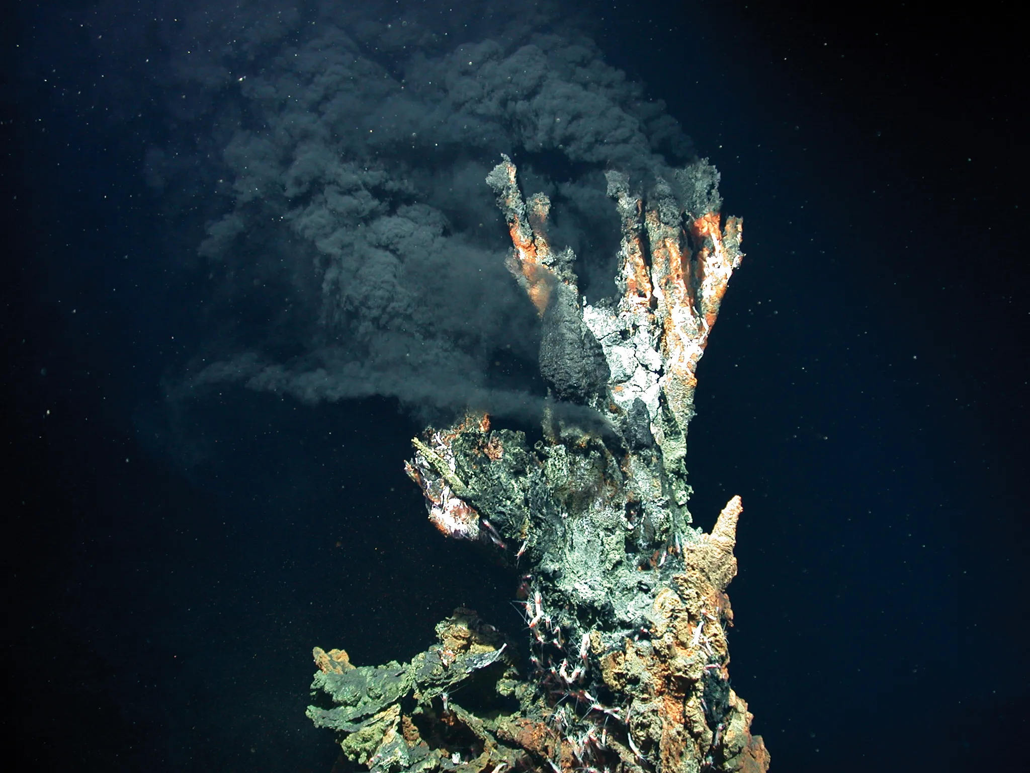 Fumego negro de uma fonte hidrotermal no fundo do oceano, com água escura rica em minerais saindo de uma chaminé submarina